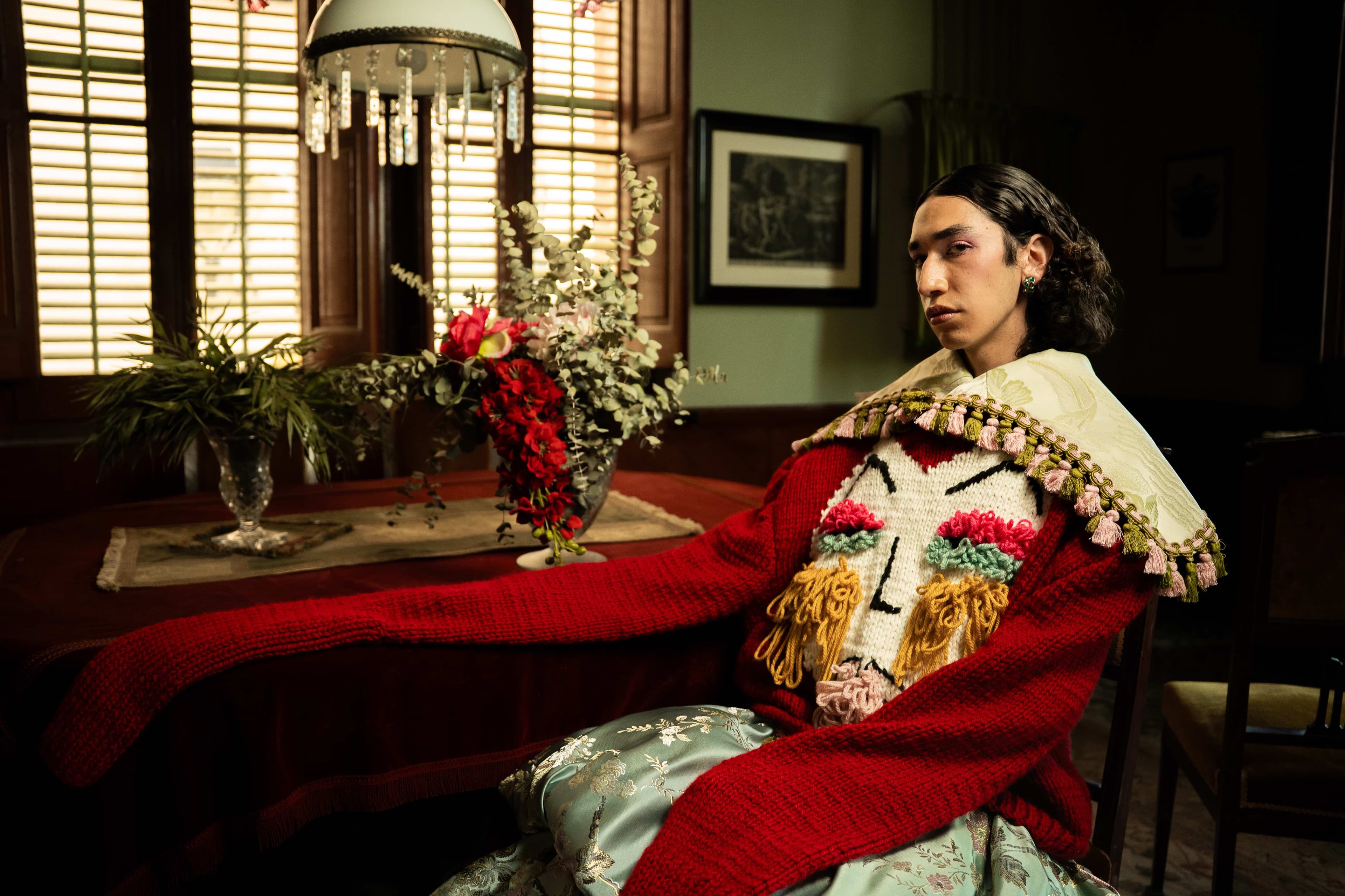 Puppet Riot FW25 Editorial - Model wearing hand-knit sweater with tassel details and brocade skirt